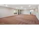 Spacious living room with carpeted floors, a large window and sliding glass door at 30876 N 128Th Dr, Peoria, AZ 85383