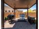 Outdoor kitchen and dining area featuring built-in grill under a modern pergola at 30876 N 128Th Dr, Peoria, AZ 85383