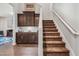 Staircase with carpeted steps and white handrail, adjacent to a dark wood built-in cabinet at 30876 N 128Th Dr, Peoria, AZ 85383