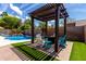Inviting backyard featuring a pergola, comfortable seating and a refreshing pool with a rock waterfall feature at 3793 E Lexington Ave, Gilbert, AZ 85234