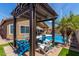 Charming backyard featuring a pergola, refreshing pool, lush palm trees, and comfortable seating area for entertaining at 3793 E Lexington Ave, Gilbert, AZ 85234