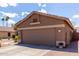 Side view of a tan single-story home featuring a two-car garage, desert landscaping, and blue skies at 3793 E Lexington Ave, Gilbert, AZ 85234
