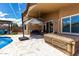 Relaxing covered patio features comfortable seating, an umbrella and tile flooring next to the inviting pool at 3793 E Lexington Ave, Gilbert, AZ 85234