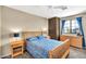 Well-lit bedroom features a wooden bed with blue floral cover, nightstands, and large window at 3854 E Cathedral Rock Dr, Phoenix, AZ 85044