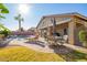 Relaxing backyard featuring desert landscaping, lounge chair, and outdoor dining set at 40853 W Bravo Dr, Maricopa, AZ 85138