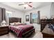 Bedroom with a large window, carpet, wooden furniture, and a red and blue plaid comforter at 40853 W Bravo Dr, Maricopa, AZ 85138