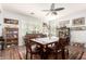 Dining room features a ceiling fan, wood floors, and a traditional-style table with seating for six at 40853 W Bravo Dr, Maricopa, AZ 85138