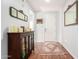 Inviting entryway featuring hardwood floors, decorative mirrors, and a stylish wooden cabinet at 40853 W Bravo Dr, Maricopa, AZ 85138