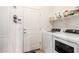 Bright laundry room with washer, dryer, and shelf storage at 40853 W Bravo Dr, Maricopa, AZ 85138