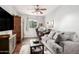 Comfortable living room area with hardwood floors, a sofa, desk, and ceiling fan at 40853 W Bravo Dr, Maricopa, AZ 85138