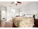 Bedroom featuring a floral comforter, hardwood floors, and natural light streaming in from a window at 40853 W Bravo Dr, Maricopa, AZ 85138