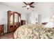 Bedroom with a floral comforter, ceiling fan, hardwood floors, and ample natural light at 40853 W Bravo Dr, Maricopa, AZ 85138