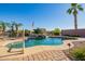 Beautiful pool with rock waterfall feature and mature palm trees overlooking water at 40853 W Bravo Dr, Maricopa, AZ 85138
