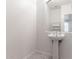 Modern powder room featuring a pedestal sink, large mirror, and neutral color palette at 4368 E Cullumber St, Gilbert, AZ 85234