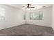 Bedroom features neutral carpeting, a ceiling fan, two windows, and neutral walls at 4368 E Cullumber St, Gilbert, AZ 85234