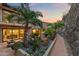 Beautiful backyard landscaping with palm trees and a stone-lined walkway at a luxury home at dusk at 4536 E Foothill Dr, Paradise Valley, AZ 85253