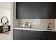 Modern bar area features dark cabinets, mosaic backsplash, sink, and marble countertops at 4536 E Foothill Dr, Paradise Valley, AZ 85253