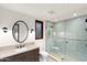 Modern bathroom with tiled walk-in shower, dark vanity, framed round mirror, and elegant fixtures at 4536 E Foothill Dr, Paradise Valley, AZ 85253