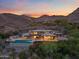 Stunning modern home featuring a pool, outdoor seating, and beautiful desert landscaping at sunset at 4536 E Foothill Dr, Paradise Valley, AZ 85253