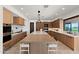 Bright kitchen featuring custom wood cabinets, modern appliances, a large island with seating, and light stone floors at 4536 E Foothill Dr, Paradise Valley, AZ 85253