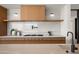 Kitchen featuring a marble backsplash, open shelving, custom cabinets, stainless steel appliances, and a large island at 4536 E Foothill Dr, Paradise Valley, AZ 85253