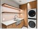 Well-lit laundry room with wooden cabinets, floating shelves, white countertop, and stacked washer/dryer units at 4536 E Foothill Dr, Paradise Valley, AZ 85253