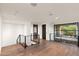 Bright loft area with hardwood floors, black metal railings, a large window, and modern lighting at 4536 E Foothill Dr, Paradise Valley, AZ 85253