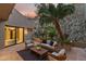 Covered outdoor patio featuring modern seating area, decorative rock wall and open entry to the spa-like bathroom at 4536 E Foothill Dr, Paradise Valley, AZ 85253