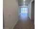 Inviting home hallway showcasing stylish wood-look flooring, leading to a bright and airy living space with sliding glass doors at 47253 W Pecan Woods --, Maricopa, AZ 85139