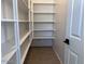 Walk-in pantry features white shelving for ample storage space and tile floors at 47253 W Pecan Woods --, Maricopa, AZ 85139