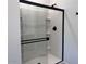 Modern bathroom shower with glass door, black hardware, and built-in shelving at 47253 W Pecan Woods --, Maricopa, AZ 85139