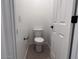 Small powder room featuring a white toilet and white door with black hardware at 47253 W Pecan Woods --, Maricopa, AZ 85139