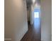 Hallway with wood-look tile floors and neutral walls with sunlight streaming through a window at the end at 47748 W Moeller Rd, Maricopa, AZ 85139