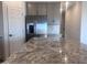 A modern kitchen showcases stainless steel appliances and gray-speckled granite countertops at 47748 W Moeller Rd, Maricopa, AZ 85139