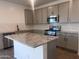 Modern kitchen with gray cabinets, a center island, and stainless steel appliances at 47748 W Moeller Rd, Maricopa, AZ 85139