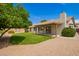 Manicured backyard with lush green lawn, mature landscaping, covered patio, and decorative rock groundcover at 5011 E Nisbet Rd, Scottsdale, AZ 85254