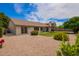 Extensive rock landscape backyard with manicured grass, covered patio, and mature trees and bushes at 5011 E Nisbet Rd, Scottsdale, AZ 85254
