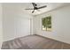 Bedroom features ceiling fan, plush carpet, window with view to outdoors, and closet with paneled doors at 5011 E Nisbet Rd, Scottsdale, AZ 85254