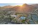 Stunning aerial view of community amenities, including pool, clubhouse, and tennis courts, nestled against a picturesque mountain backdrop at 5233 N 207Th Dr, Buckeye, AZ 85396