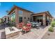 Inviting backyard patio with a fire pit, dining set, and comfortable seating at 5233 N 207Th Dr, Buckeye, AZ 85396