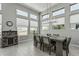 Bright dining room featuring a modern chandelier and a view of the desert landscape from the oversized windows at 5233 N 207Th Dr, Buckeye, AZ 85396