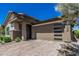 Beautiful single-story home featuring a large front-facing three car garage and a brick paved driveway at 5233 N 207Th Dr, Buckeye, AZ 85396