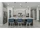 Spacious kitchen island with modern lighting, seating for three, and gray cabinets at 5233 N 207Th Dr, Buckeye, AZ 85396