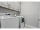 Modern laundry room with updated appliances and ample storage space at 5233 N 207Th Dr, Buckeye, AZ 85396