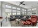 Bright living room with large windows, a sectional sofa, and a ceiling fan at 5233 N 207Th Dr, Buckeye, AZ 85396