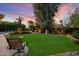 Lush backyard featuring green grass, a pergola and an outdoor seating area at 5334 E Everett Dr, Scottsdale, AZ 85254