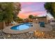 Backyard featuring a pool, covered patio, lush landscaping and rocks at 5334 E Everett Dr, Scottsdale, AZ 85254