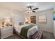 Cozy bedroom featuring carpeted floors, a leather bench, ceiling fan and a dresser with decorative lamps at 5334 E Everett Dr, Scottsdale, AZ 85254