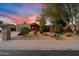 Charming home featuring desert landscaping, mature trees, and vibrant bougainvillea under a colorful sunset sky at 5334 E Everett Dr, Scottsdale, AZ 85254