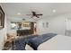 Comfortable bedroom featuring a ceiling fan, a wooden door and a console table under a wall-mounted television at 5334 E Everett Dr, Scottsdale, AZ 85254